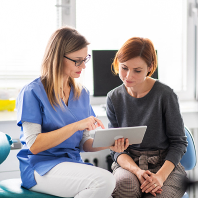 Dental assistant talking to patient about sleep apnea treatment 