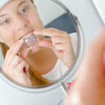 Woman putting in sleep oral appliance 