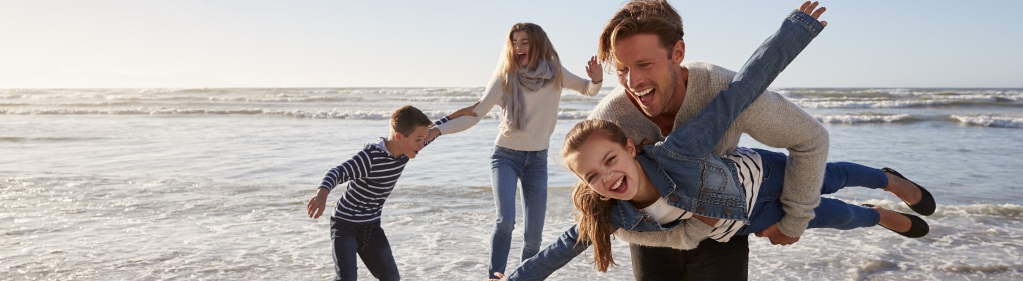 Family of four smiling together after children's dentistry