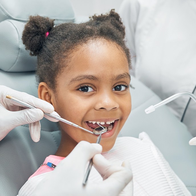 Child receiving dental checkup and teeth cleaning