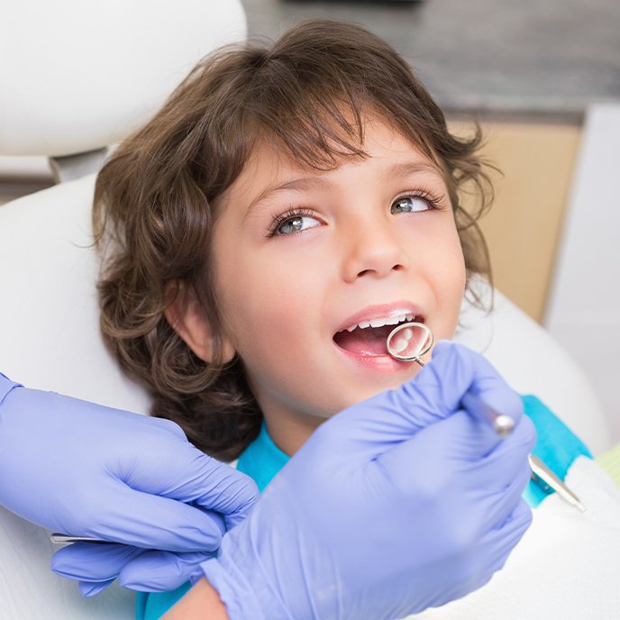 Dentist examining child's tooth colored fillings