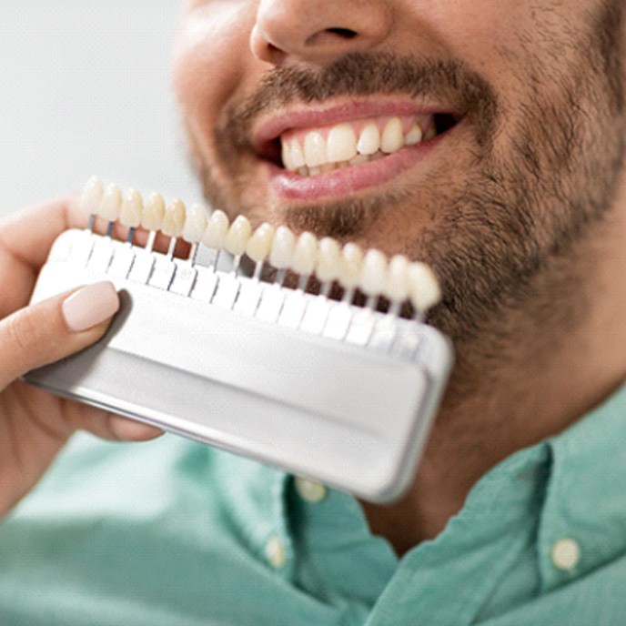 Man smiling while color-matching dental crown in Fruit Cove