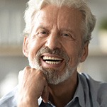 Senior man laughing with chin resting on hand