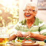 Senior woman eating a healthy meal and laughing