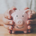 Patient holding a pink piggy bank