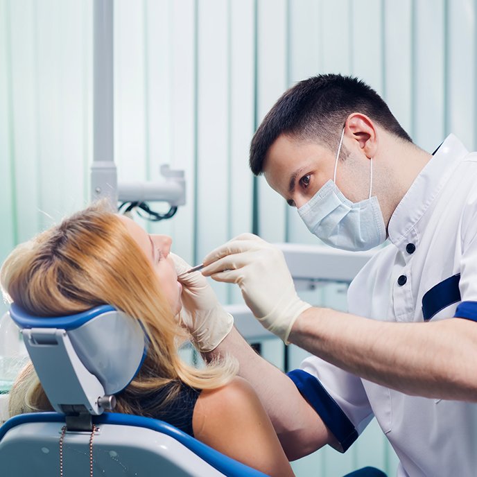 Dentist looking in female patient’s mouth
