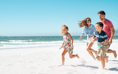 Family of four running on beach