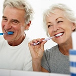 couple brushing teeth in bathroom together