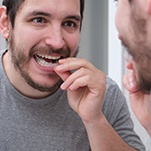 closeup of man putting on mouthguard