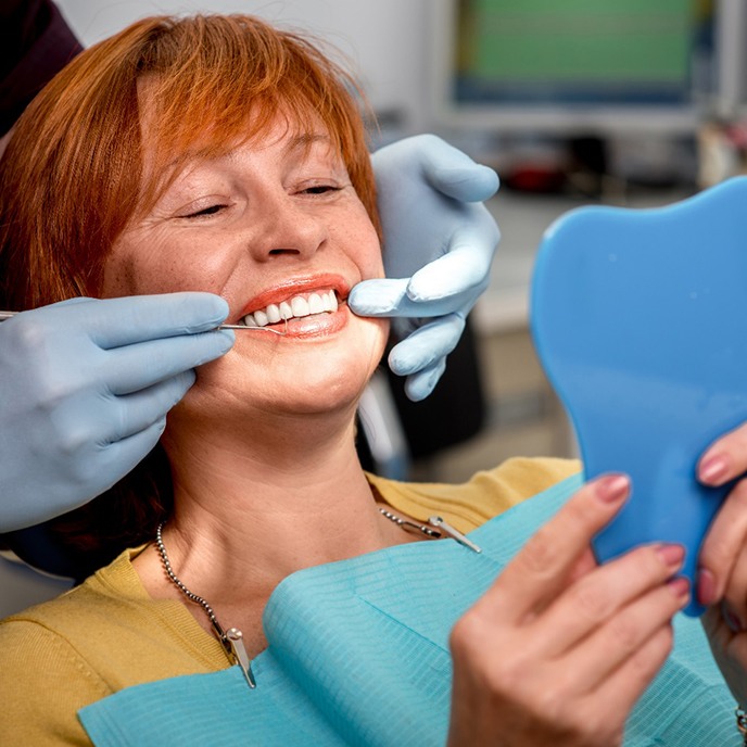 An older woman admiring his new dental implants