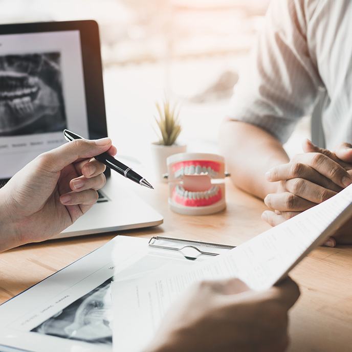 Dentist and patient reviewing dental insurance forms