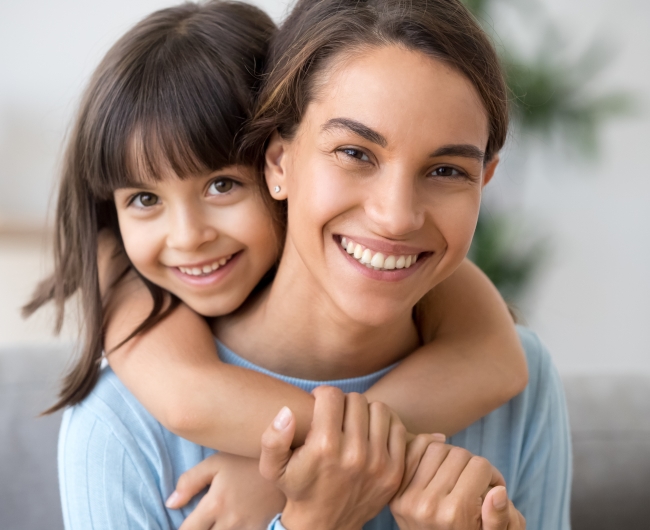 Animated mother and child smiling after children's dentistry visit