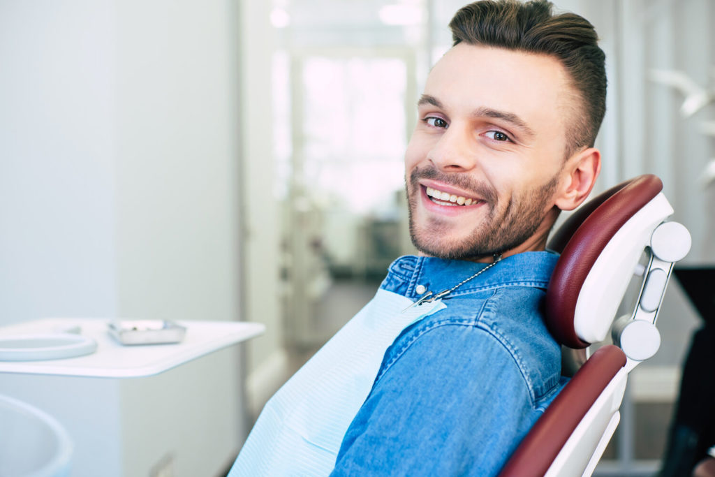 patient smiling after dentist treated dental emergency