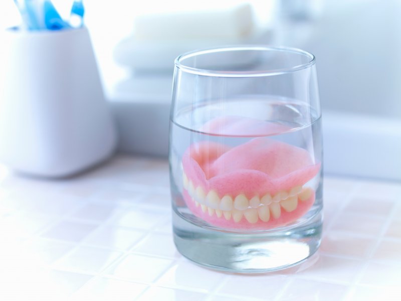 Some dentures being properly soaked overnight