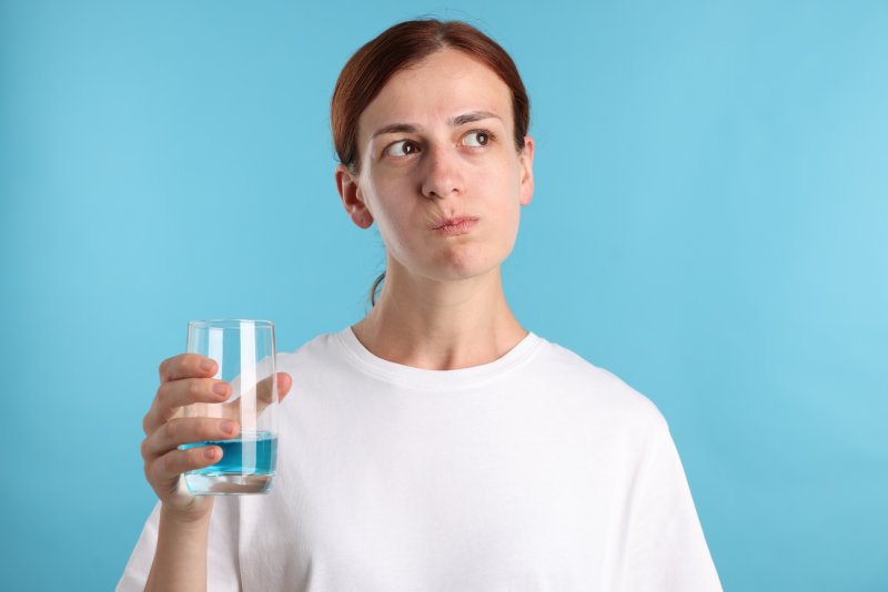 A woman rinsing her mouth with mouthwash